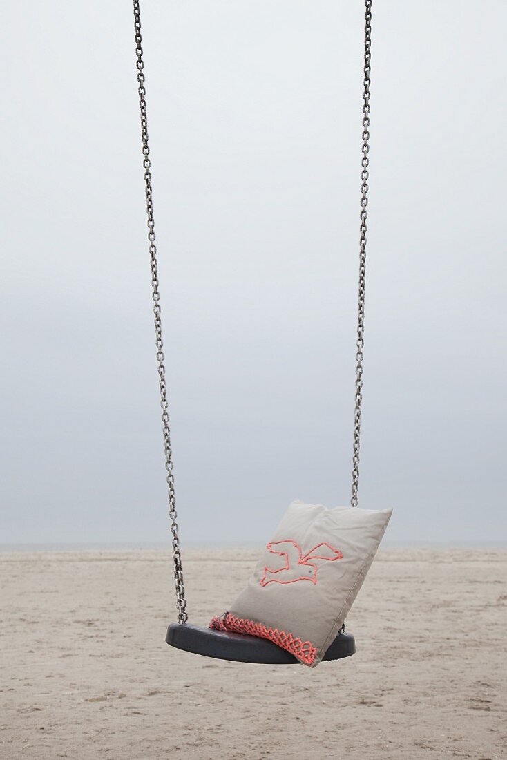 Kissen mit gehäkeltem Möwenmotiv auf Schaukel am Strand