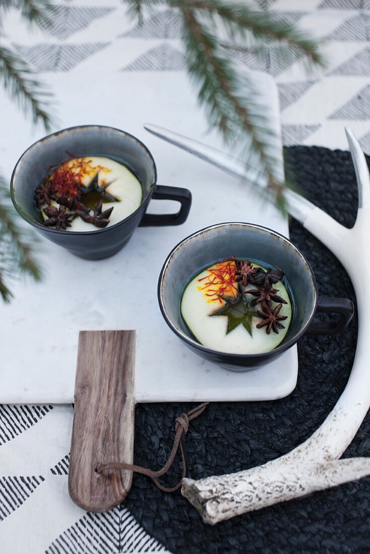 Mulled wine in cups with slices of apples, saffron and star anise