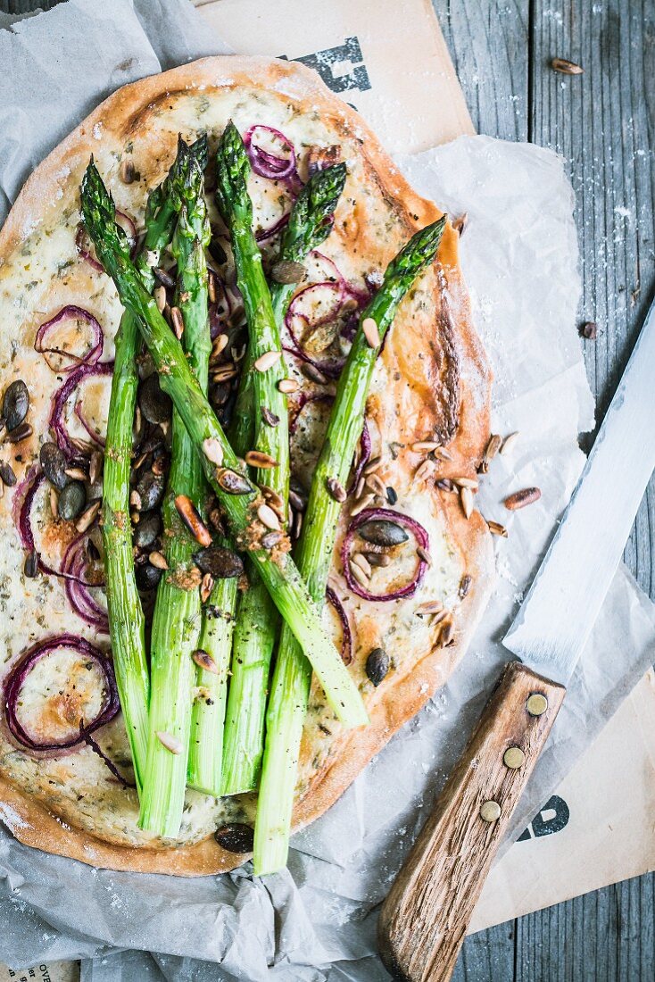 Tarte flambée with green asparagus and onion rings
