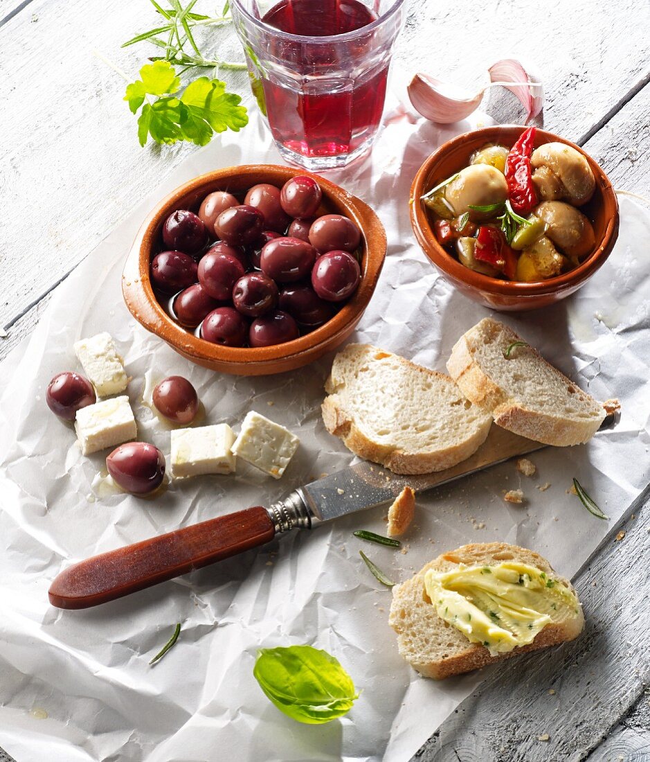 Vorspeise mit Oliven, Pilzsalat, Ziegenkäse, Brot und Rotwein