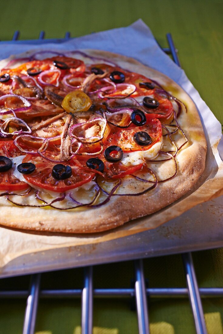 Pizza mit Tomaten, Oliven und roten Zwiebeln