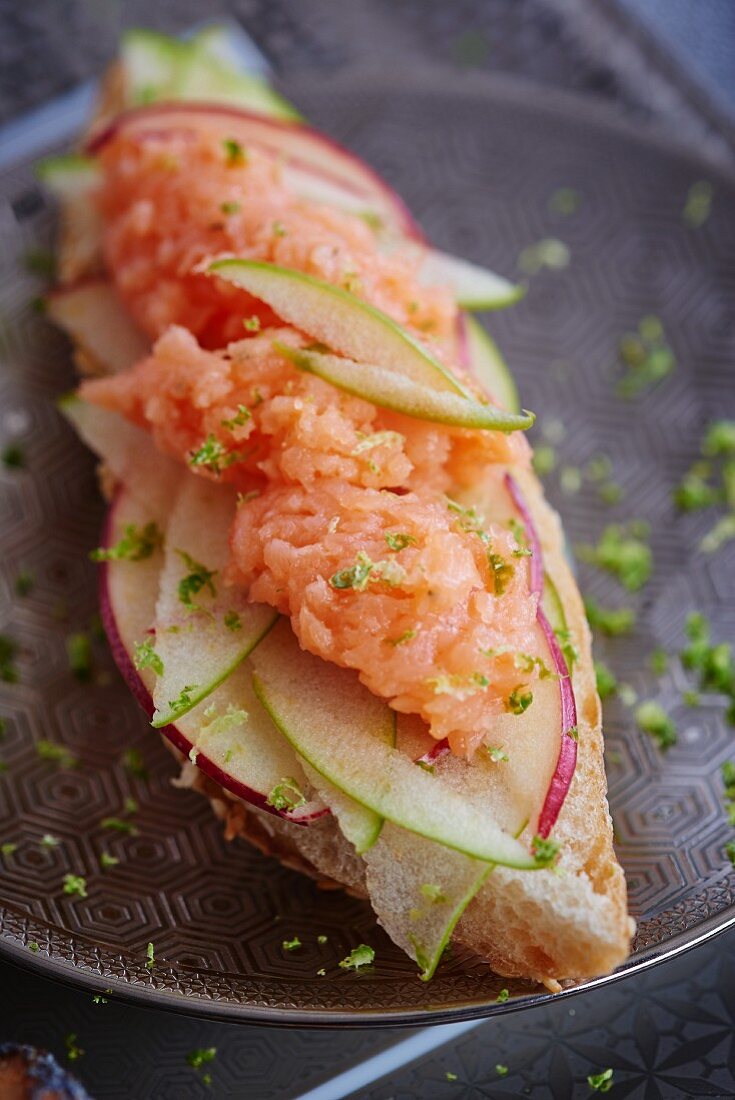 A slice of bread topped with apple and smoked salmon