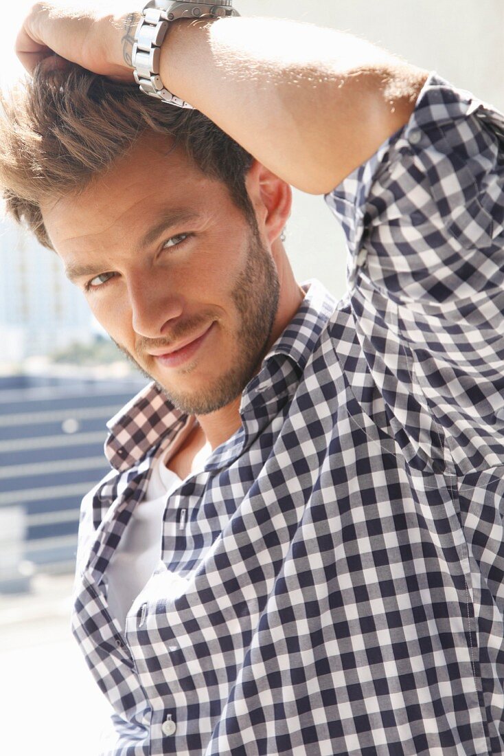 A young man with a three-day beard wearing a checked shirt