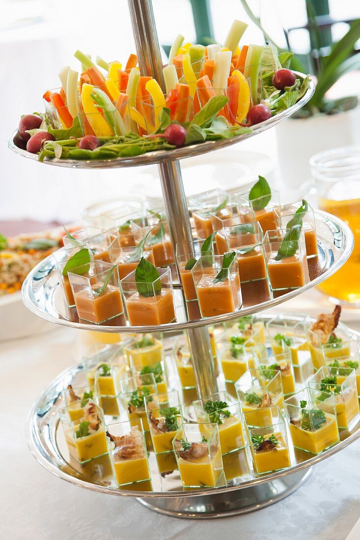Appetisers in square glasses on a large silver cake stand