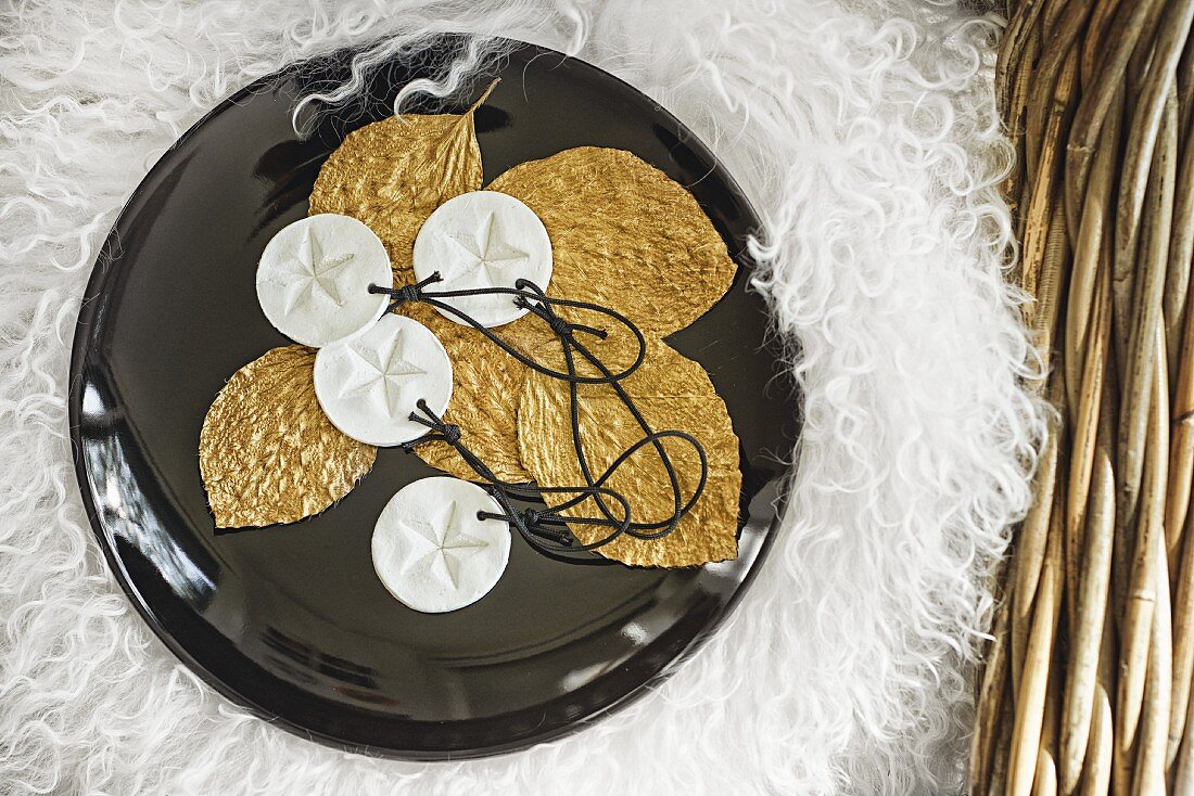 Christmas decorations; polymer clay pendants with star motifs and pressed leaved painted gold