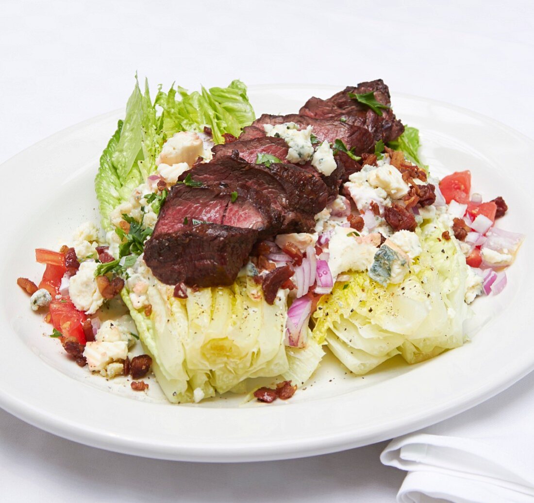 Hanger steak on lettuce hearts with bacon and blue cheese