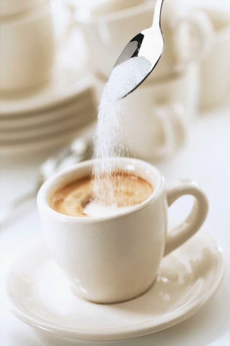 Sugar being added to an espresso