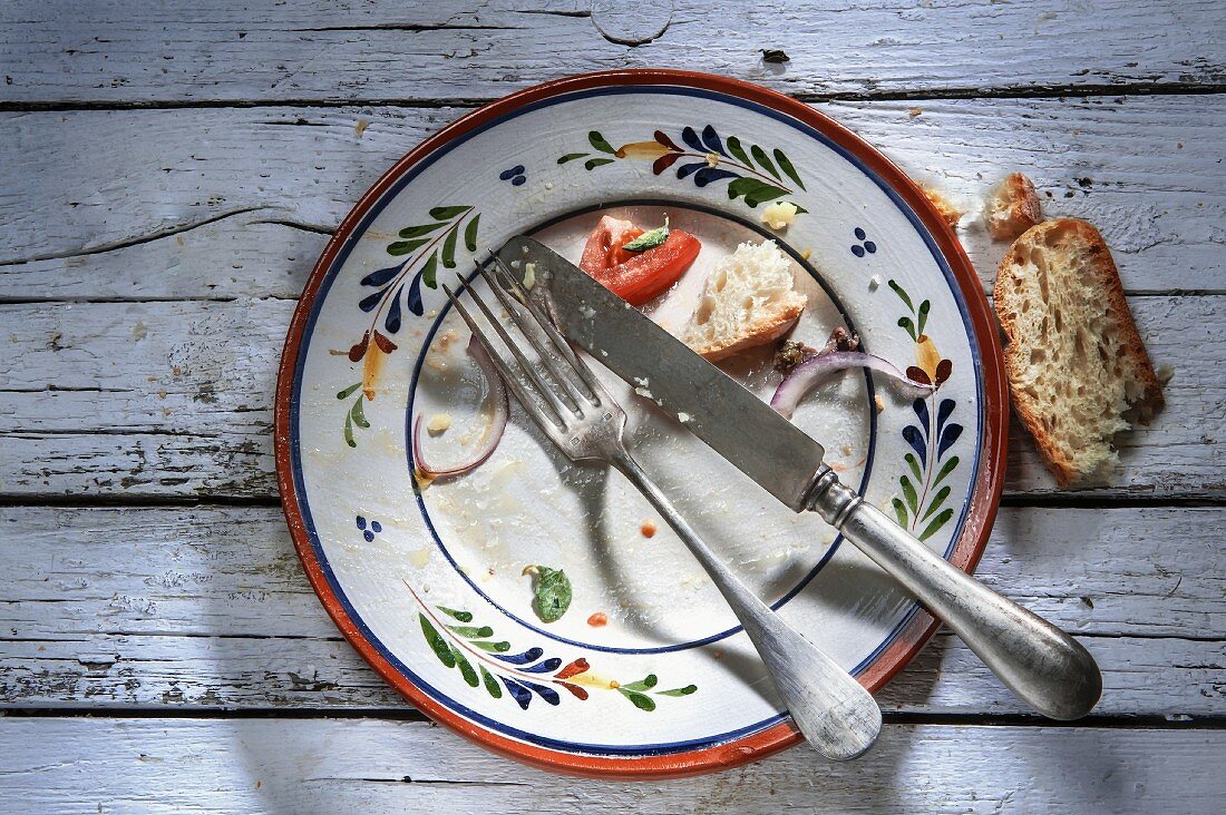 The remains of food and bread on an empty plate