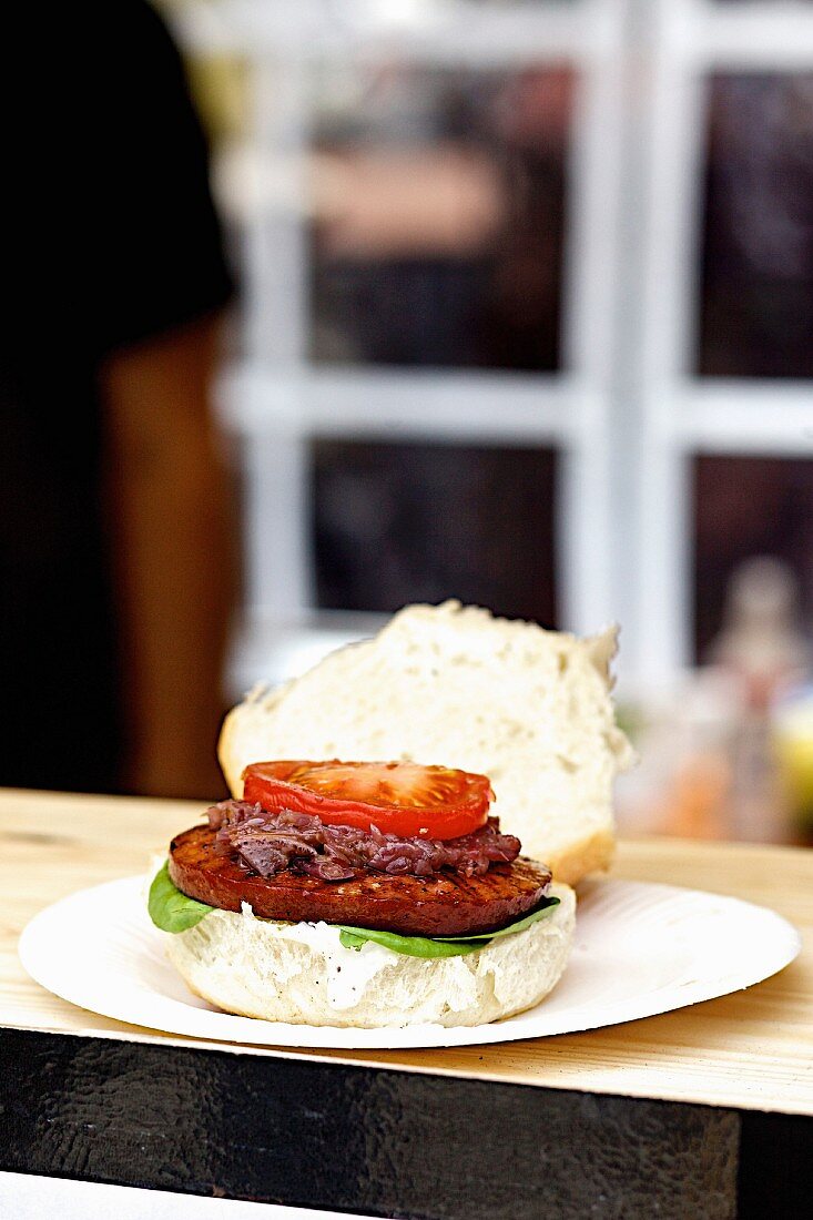 A sucuk burger on a wooden table