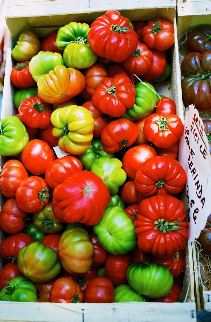 Bunte Tomaten der Sorte 'Merinda' in Holzkiste auf einem Markt in Frankreich