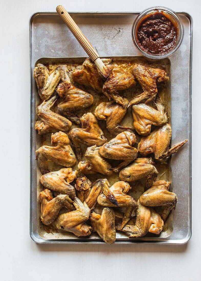 Chicken wings being brushed with marinade