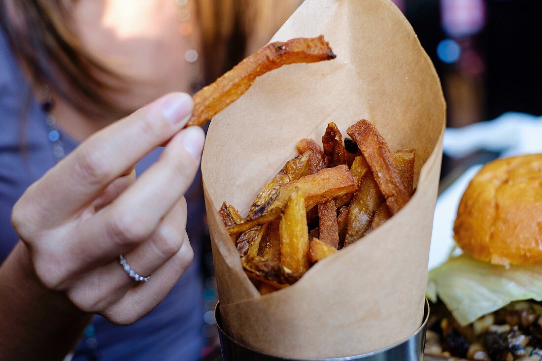 A woman eating chips from a paper bag