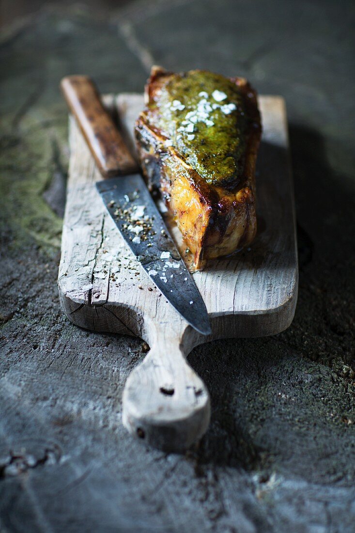 Grilled ox chop on a chopping board with a knife