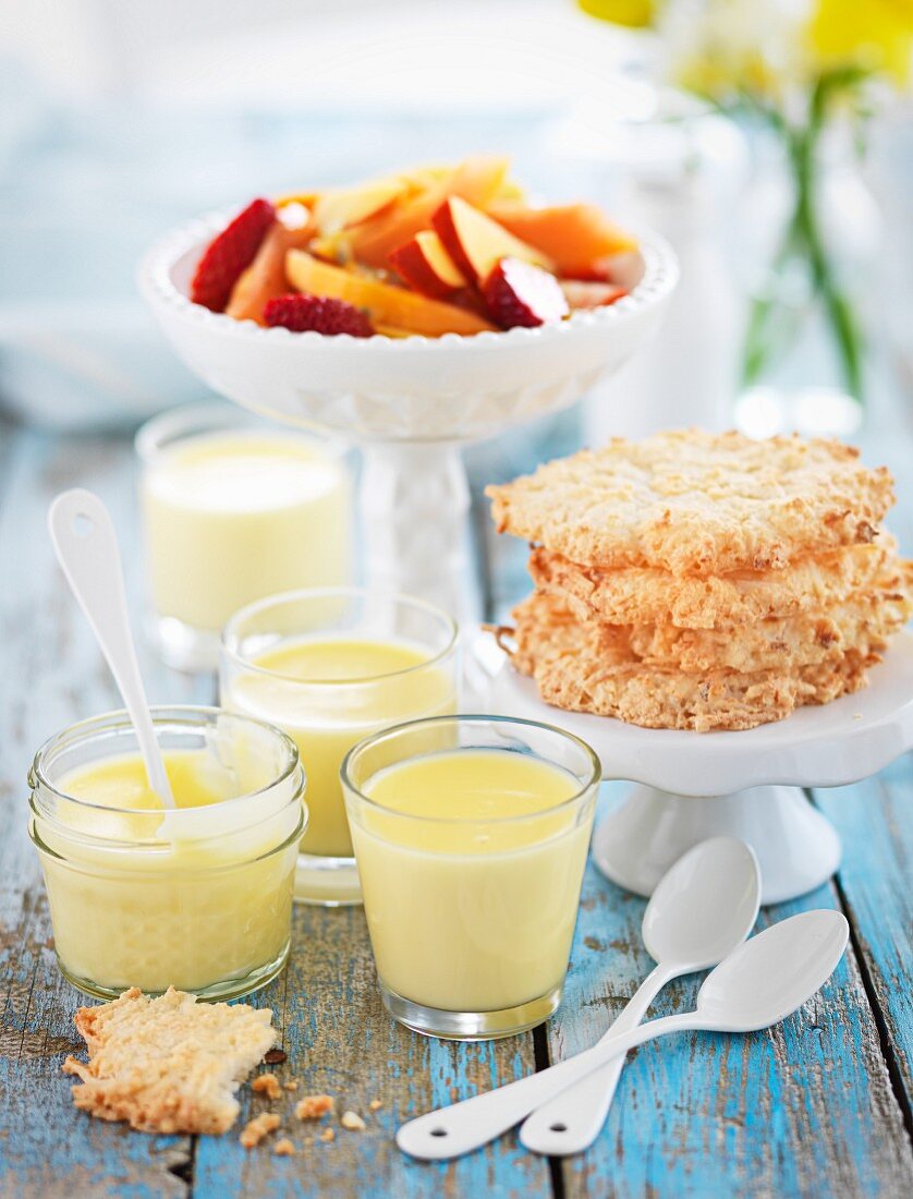 Lemon posset with biscuits and fruit salad