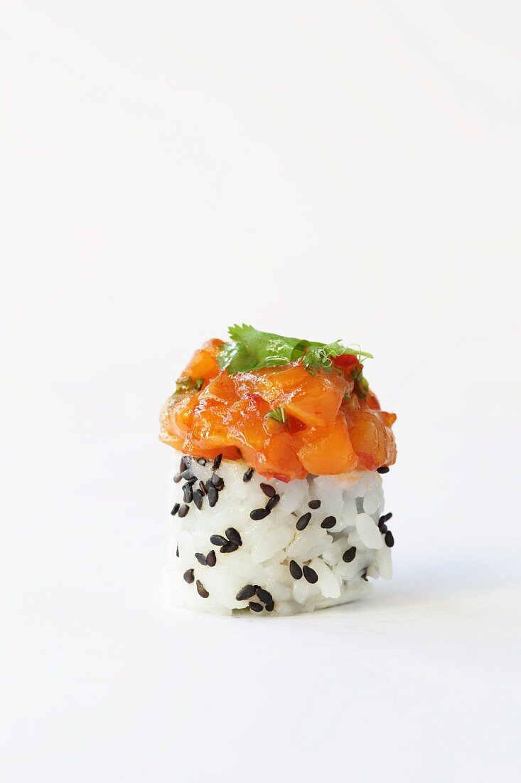 A rice canapé with black sesame seeds and salmon tatar