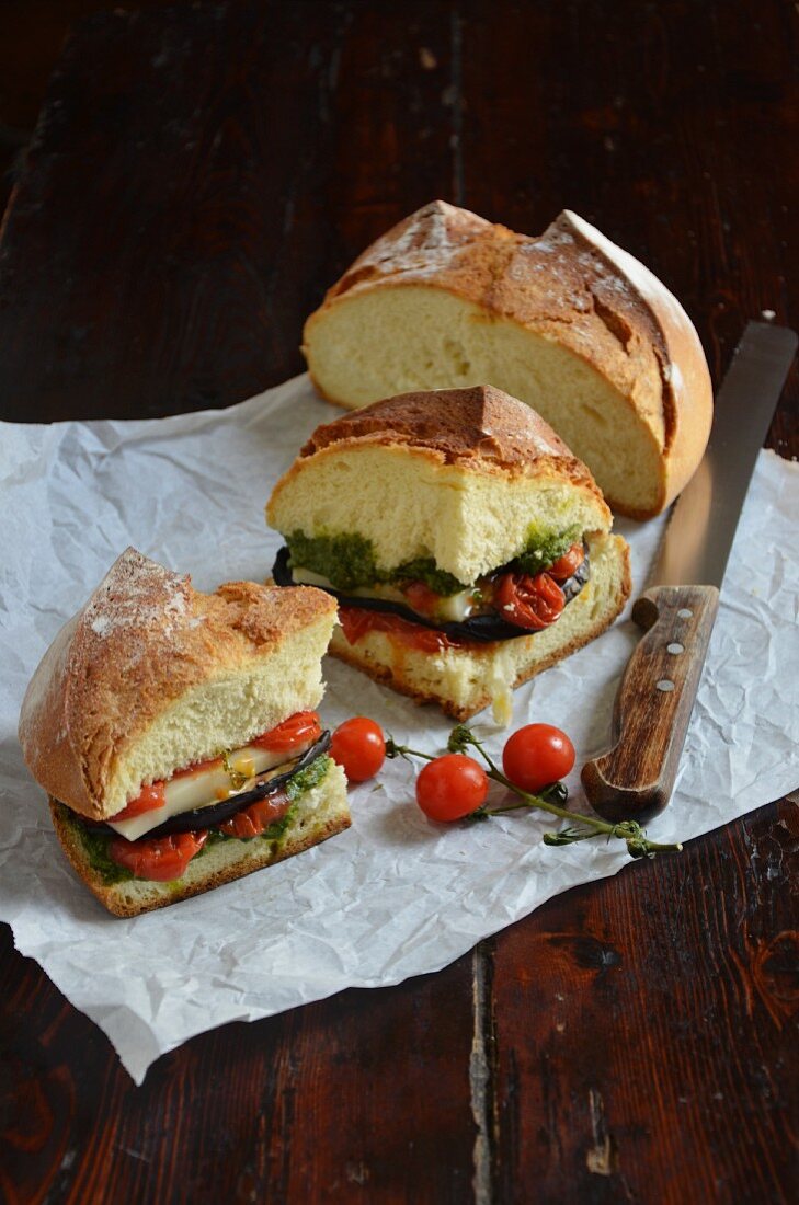 A sandwich with pesto, tomato confit and grilled vegetables