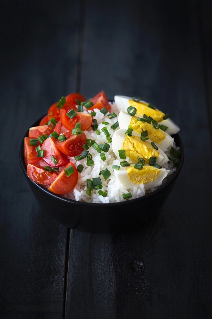 Rice salad with tomatoes, hard-boiled eggs and chives