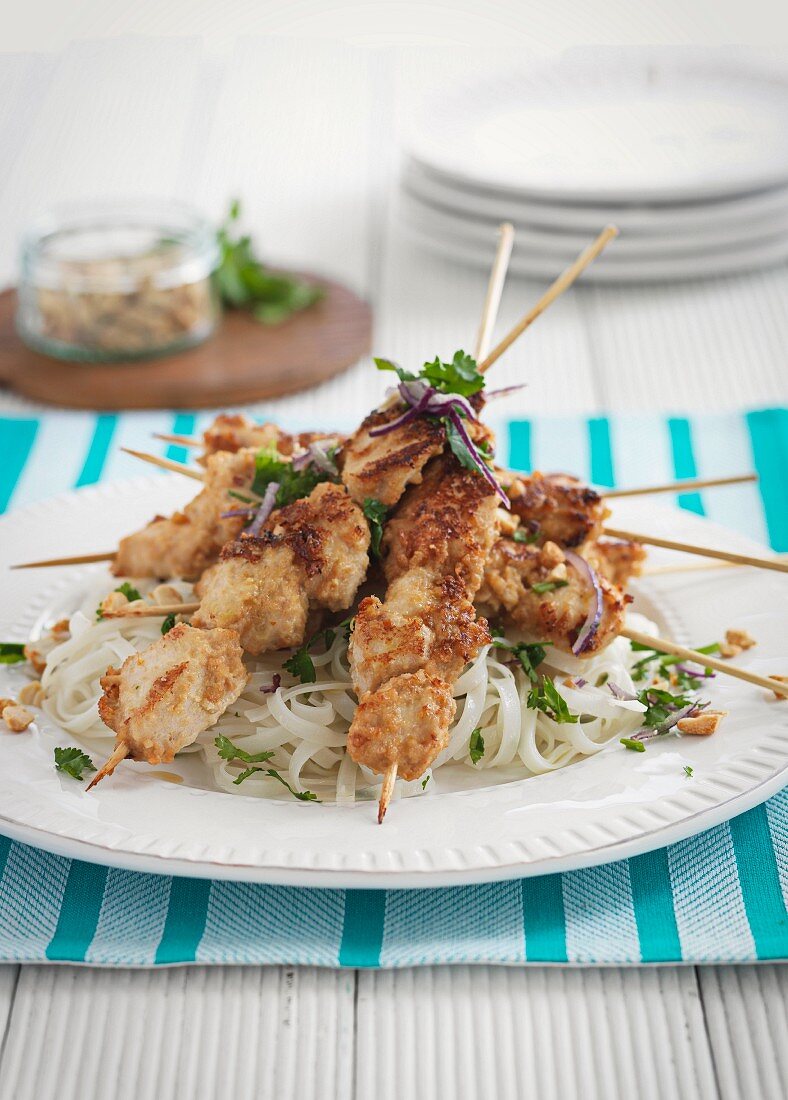 Chicken skewers on rice noodles