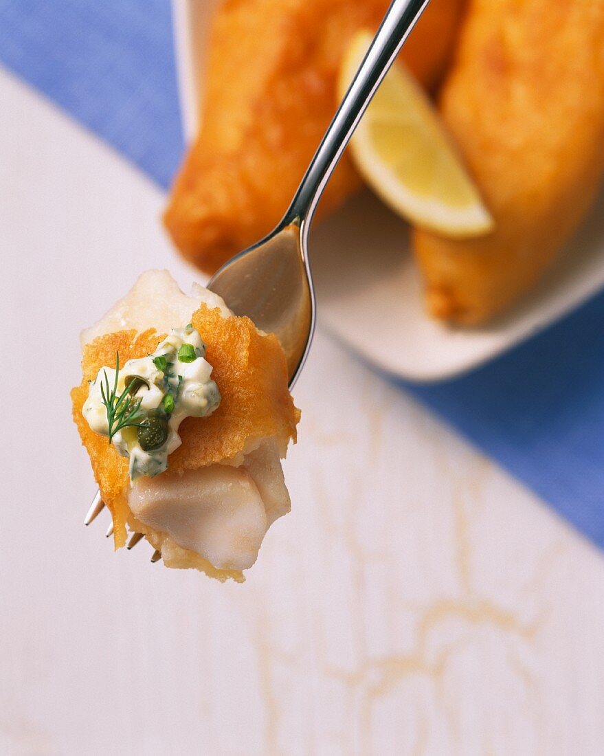 Battered fish with remoulade on a fork