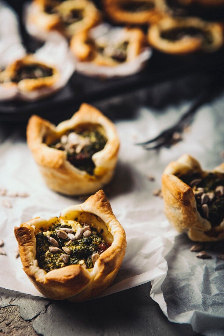 Puff pastry tartlets with spinach, tomatoes and sunflower seeds