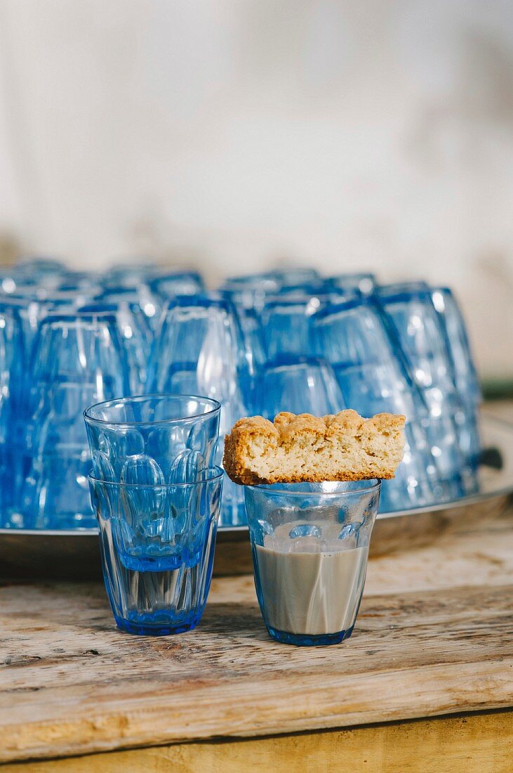 A buttermilk rusk on a glass with blue glasses in the background