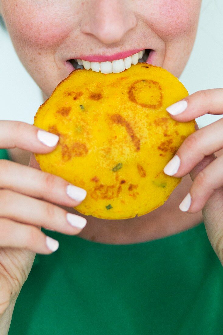 A woman biting into a pumpkin pancake