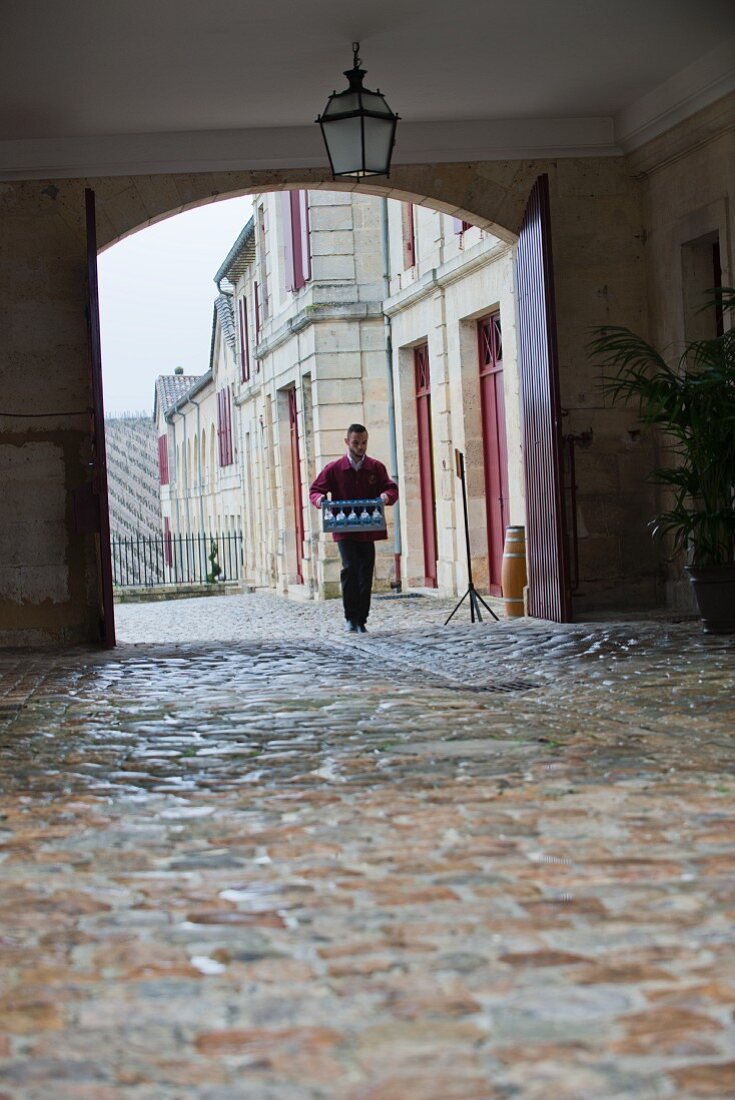 A man carrying glasses to the tasting hall at Chateau Lafite-Rothschild (Bordeaux, France)