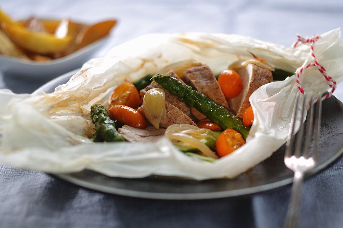 Pork fillet with vegetables and kumquats in paper