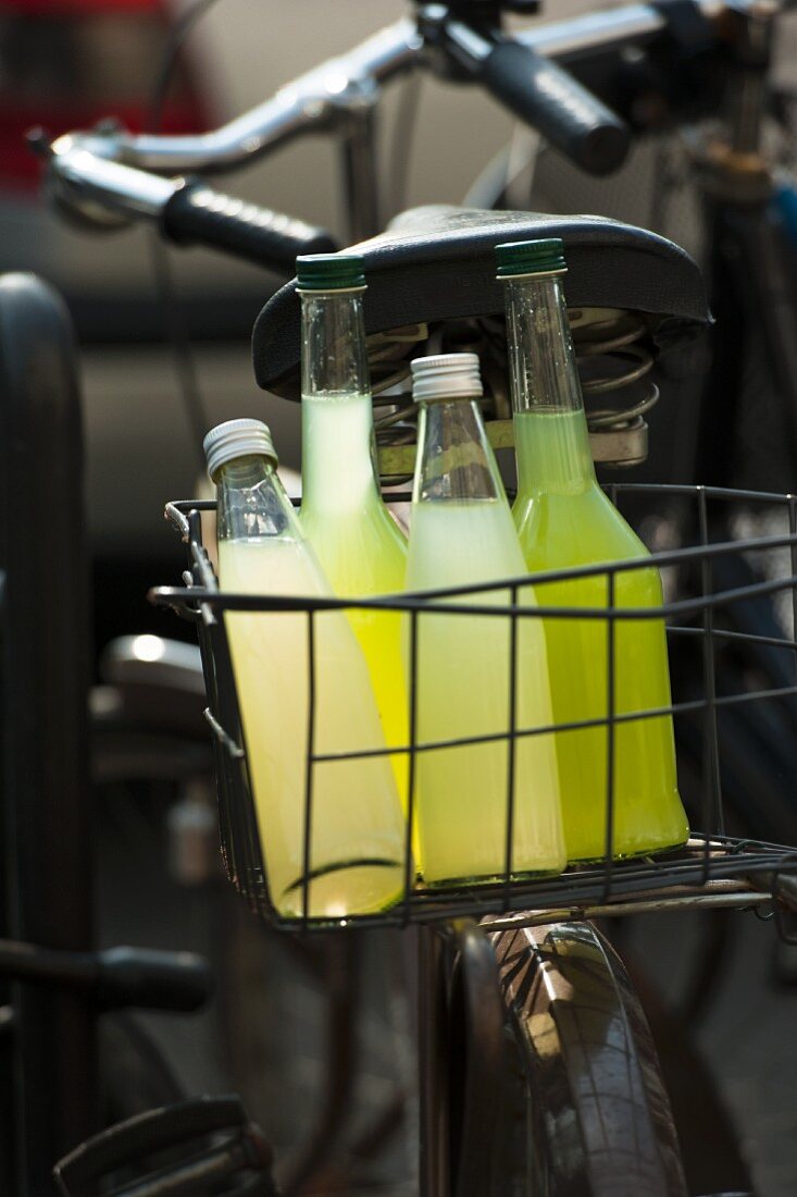 Homemade cucumber and lemonade in bottles in a bike basket