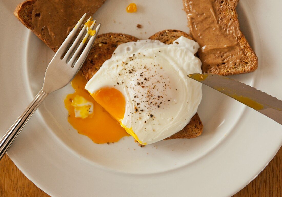 Toast with peanut butter and a poached egg on toast