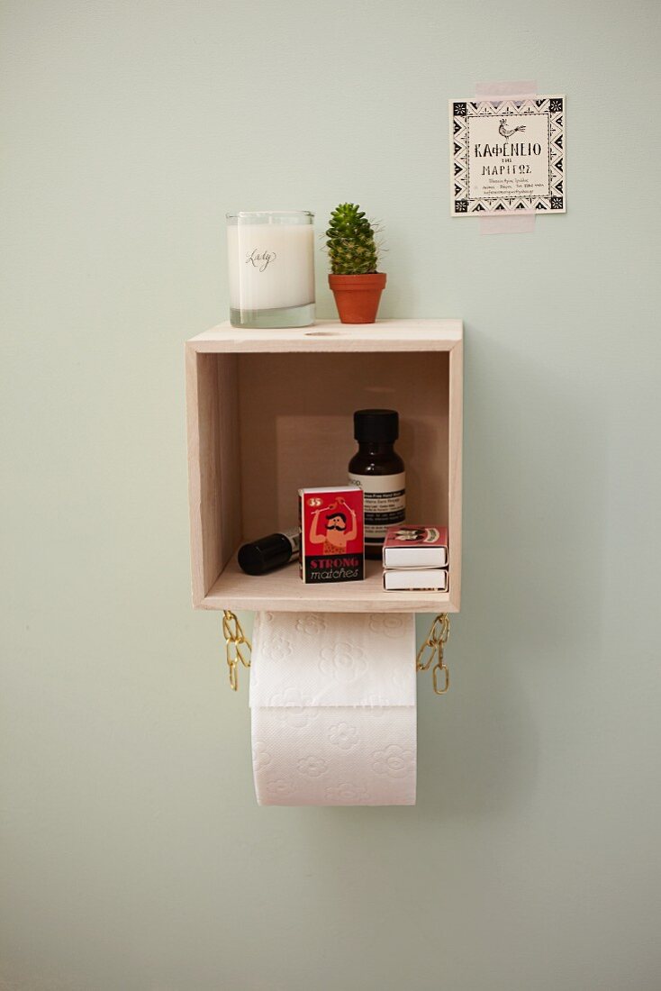 DIY shelf made from small wooden box with chain toilet roll holder below