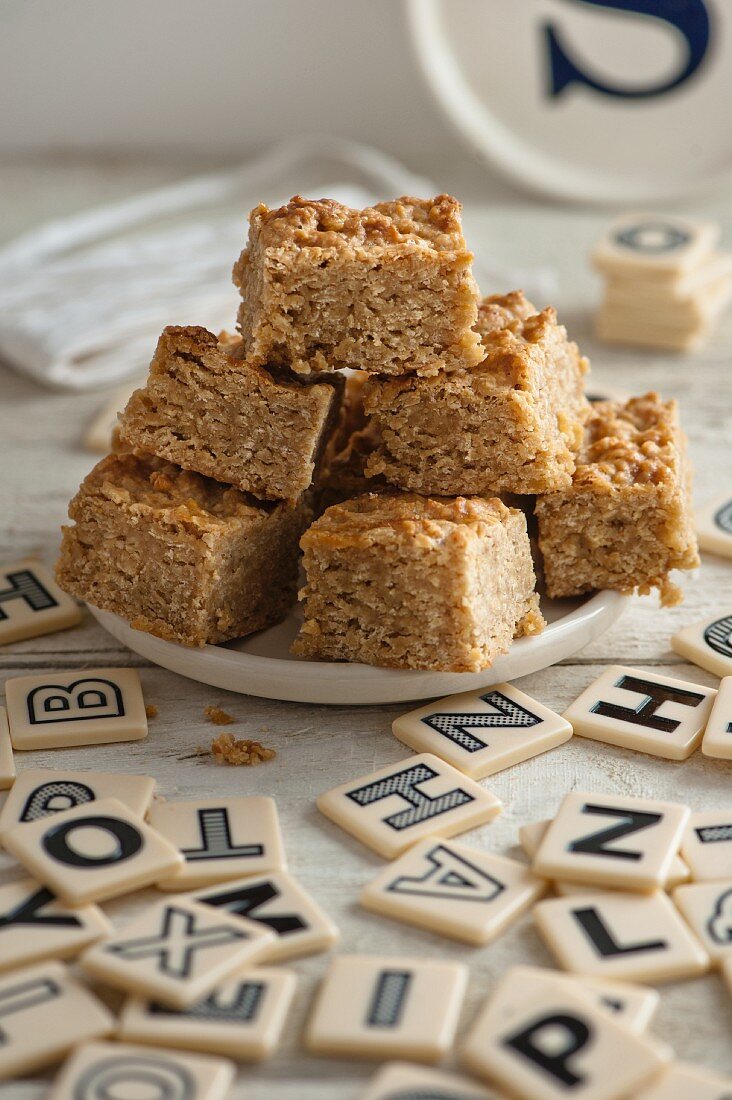 Flapjacks on a plate surrounded by letter tiles