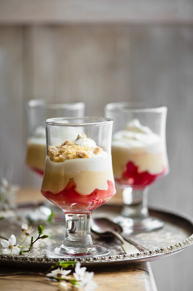 Layered desserts with rhubarb, custard, cream with oat crumbles