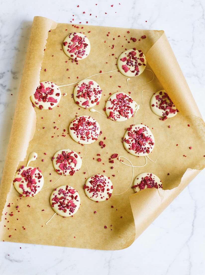 Schokoladenwaffeln mit Himbeeren und Rosen auf Backpapier