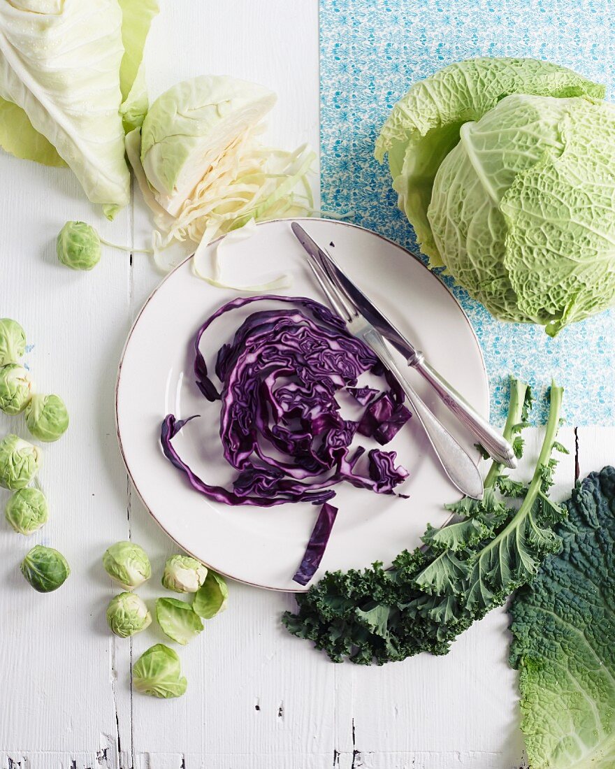 An arrangement of cabbages featuring sliced red cabbage on a plate