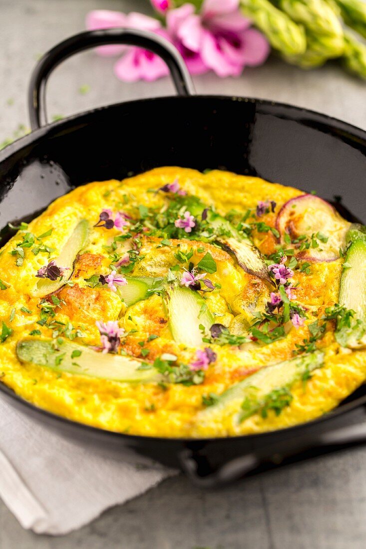 Frittata with grated asparagus, edible flowers, herbs and radishes