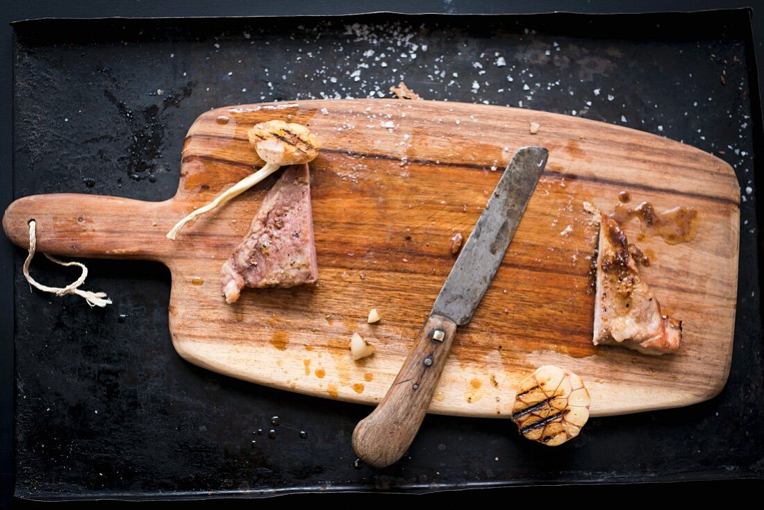 The remains of grilled Iberian pork secreto (fillet steak) with garlic