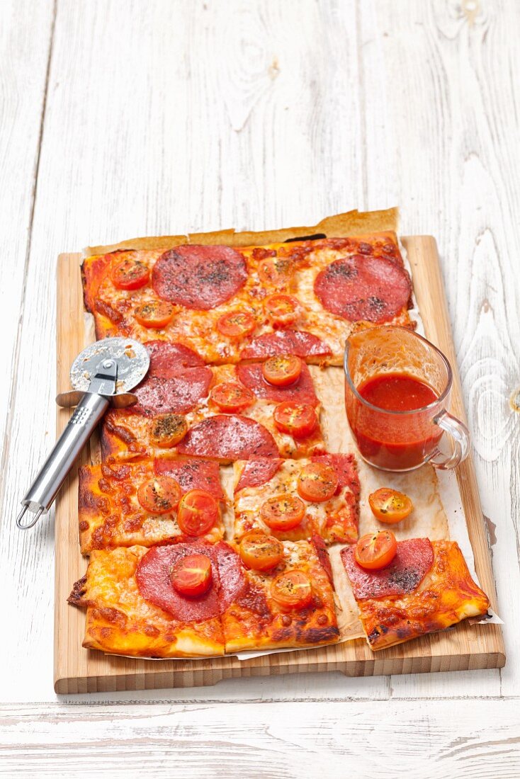 A pizza with salami and cherry tomatoes