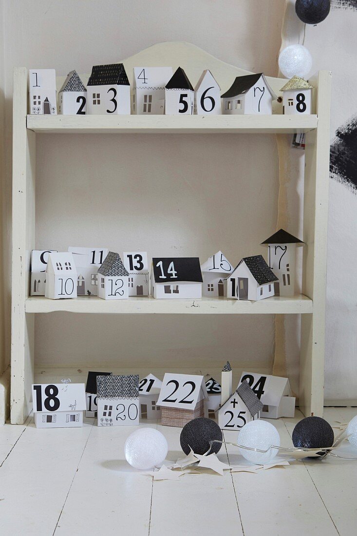 Advent calender made from black and white paper houses on shelves