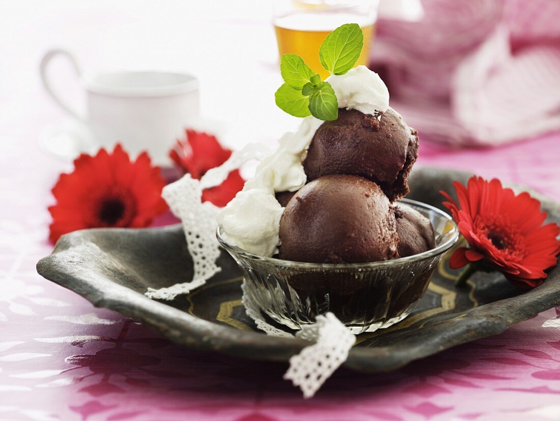 Chocolate soufflé balls with whipped cream and lemon balm