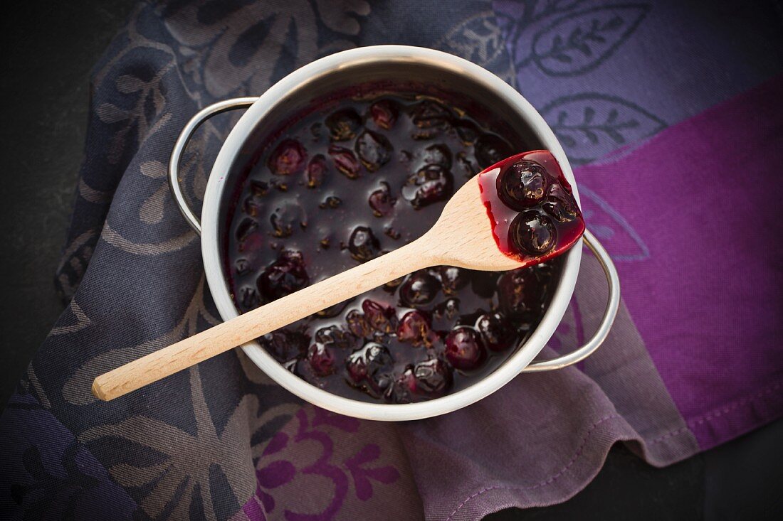 A spoonful of blueberry jam in a pot