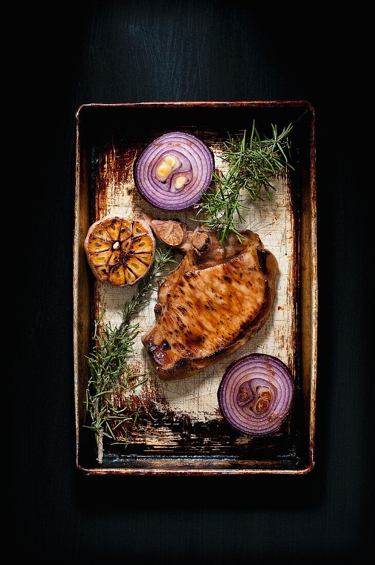 Gebratenes Schweinekotelett mit roten Zwiebeln, Knoblauch und Rosmarin