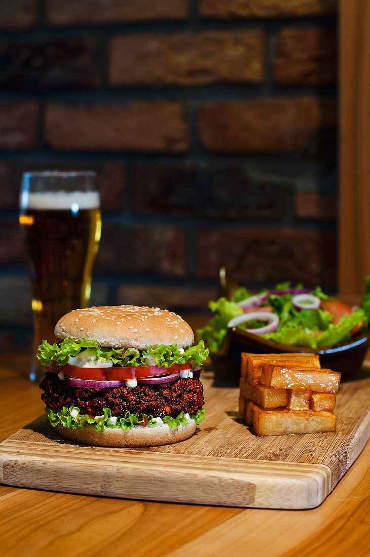 A hamburger, chips and a mixed leaf salad