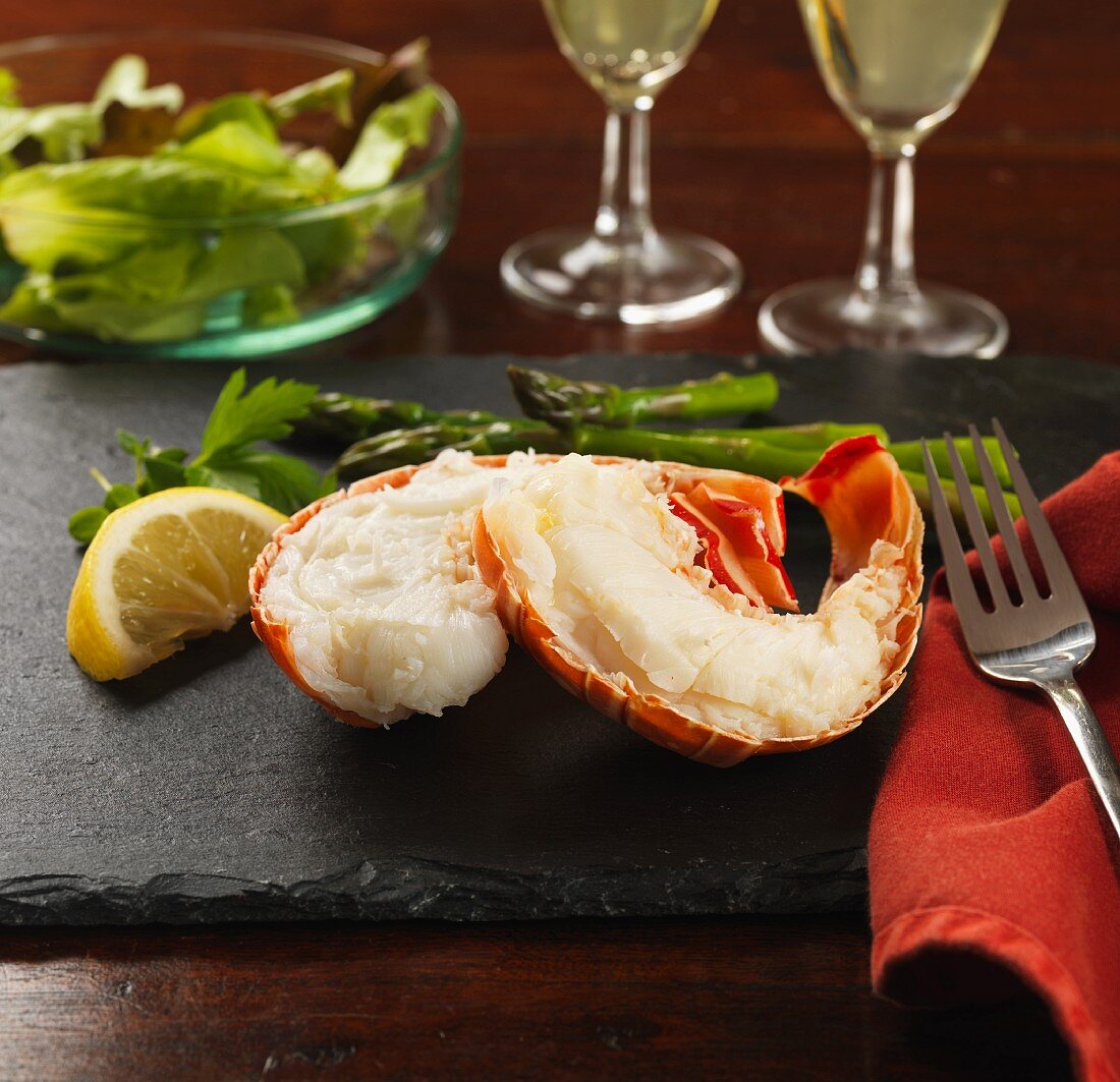 Lobster tails with lemon, asparagus and salad