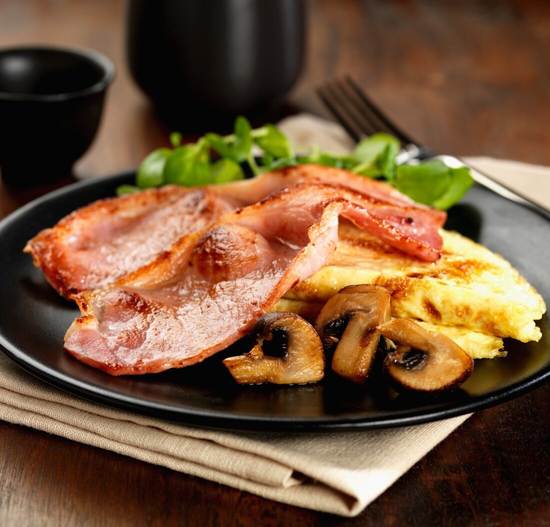 Sweet smoked bacon with a cheese omelet, mushrooms and watercress