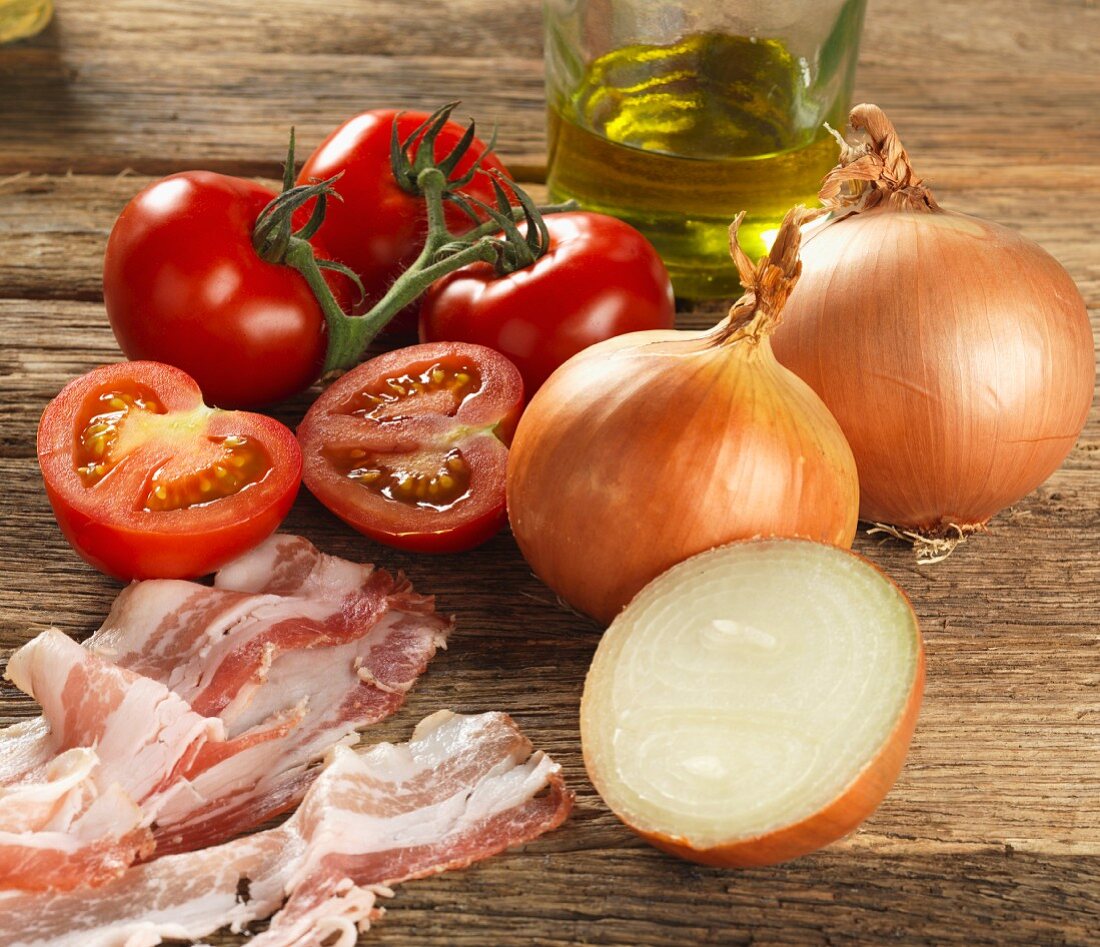 Ingredients for Tuscan pasta sauce (onions, tomatoes, bacon, olive oil)