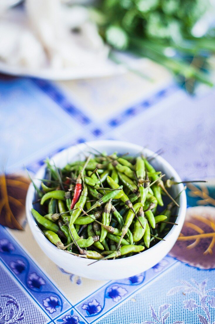 A bowl of green chilli peppers