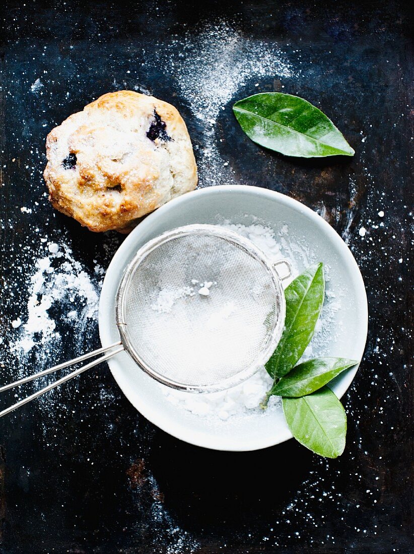 A blueberry scone and icing sugar
