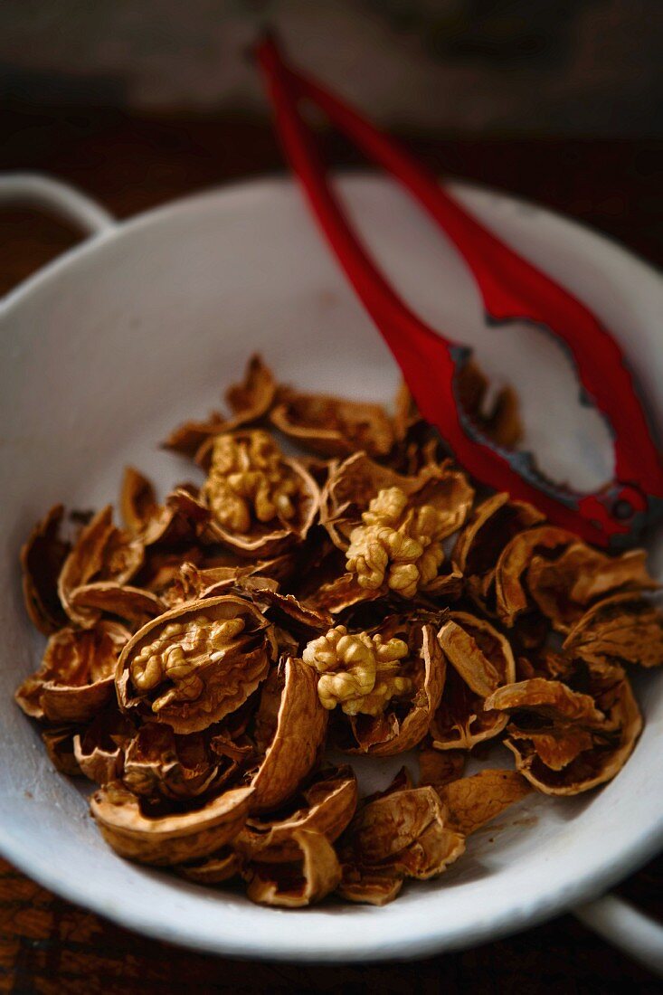 Cracked walnuts and a nutcracker in a bowl