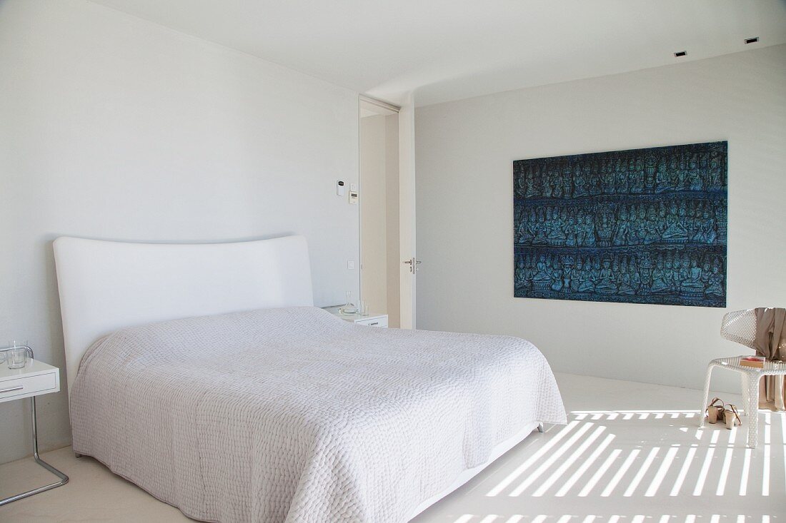 Wall decoration in shades of blue in minimalist white bedroom